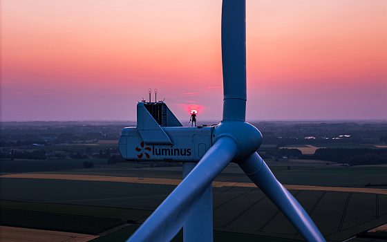 Portret bij gouden uur van Sophie Guiot (Spooky So), tatoeëerster, bij een windturbine in Haspengouw